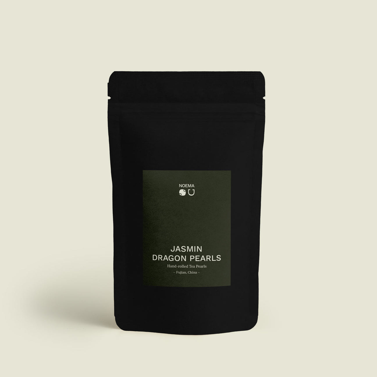 Verpackung des Jasmin Dragon Pearls Tees mit Etikett, das die elegante Verbindung von feinstem Grüntee und natürlicher Jasminblüte präsentiert.

Packaging of Jasmin Dragon Pearls Tea with label, showcasing the elegant combination of premium green tea and natural jasmine blossoms.