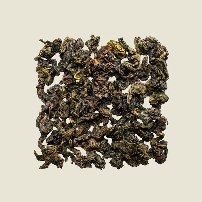 Tie Guan Yin Oolong lose ausgelegt, Draufsicht auf grünlich gerollte Blätter – klassischer Tee aus Fujian, Noema.